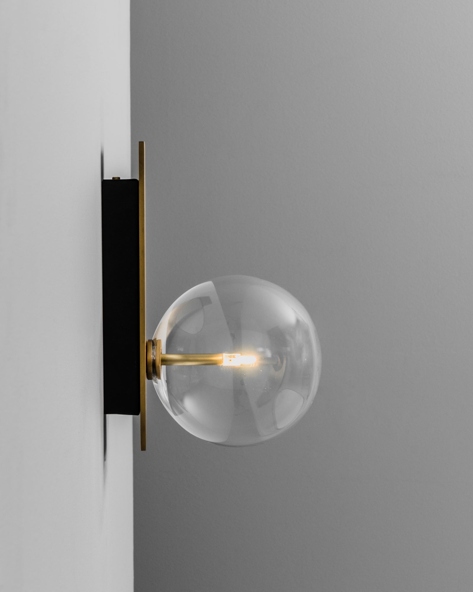 Schwung Oslo Single Burnished Brass Transparent Globe Wall Light